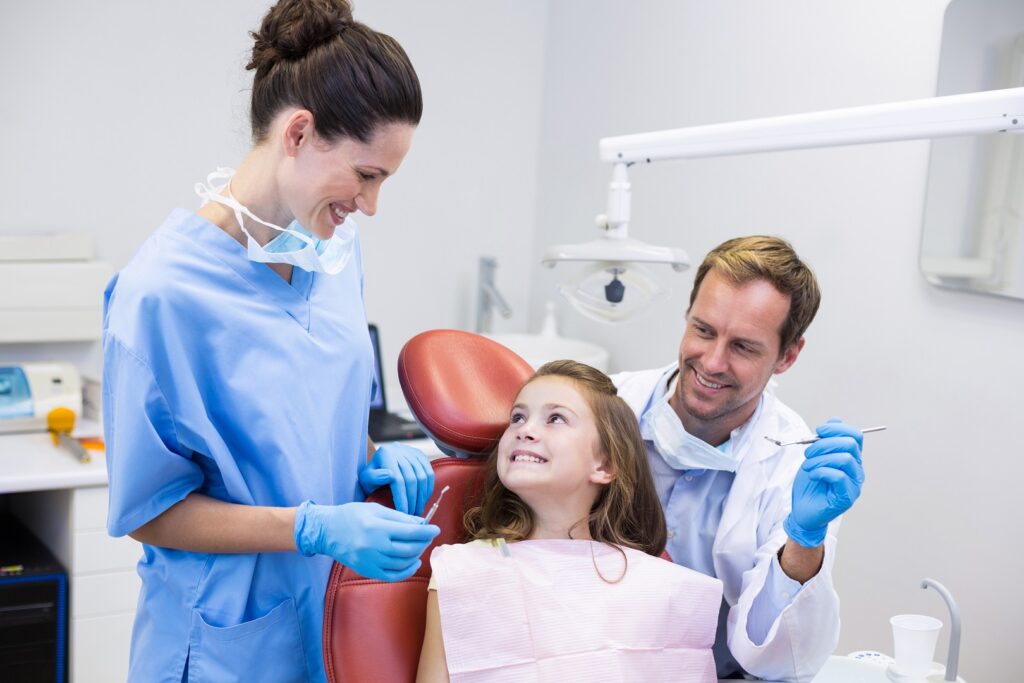 smiling-dentists-interacting-with-young-patient