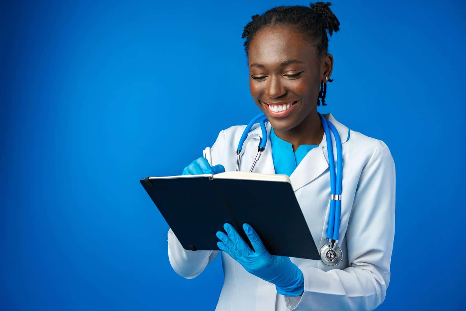 Black female doctor student wearing a lab coat with book
